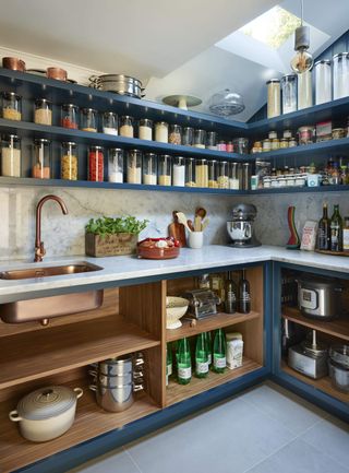 walk in kitchen pantry with all open blue shelving, countertop and basin