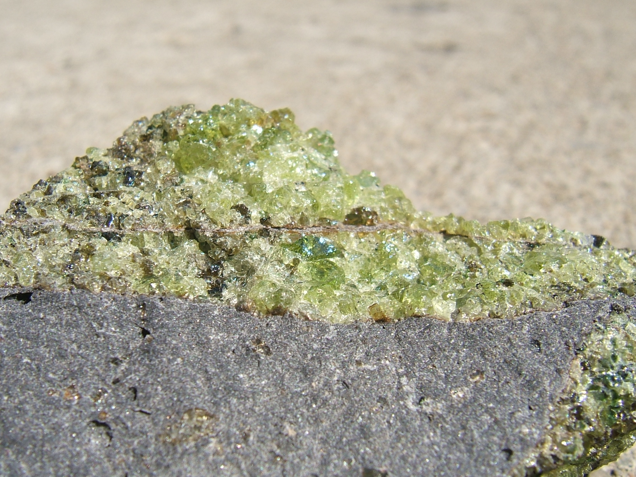 Green crystals sprouting from gray stone