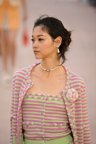 Model at Chanel wearing a wispy bun, a key Spring/Summer 2025 fashion month beauty look