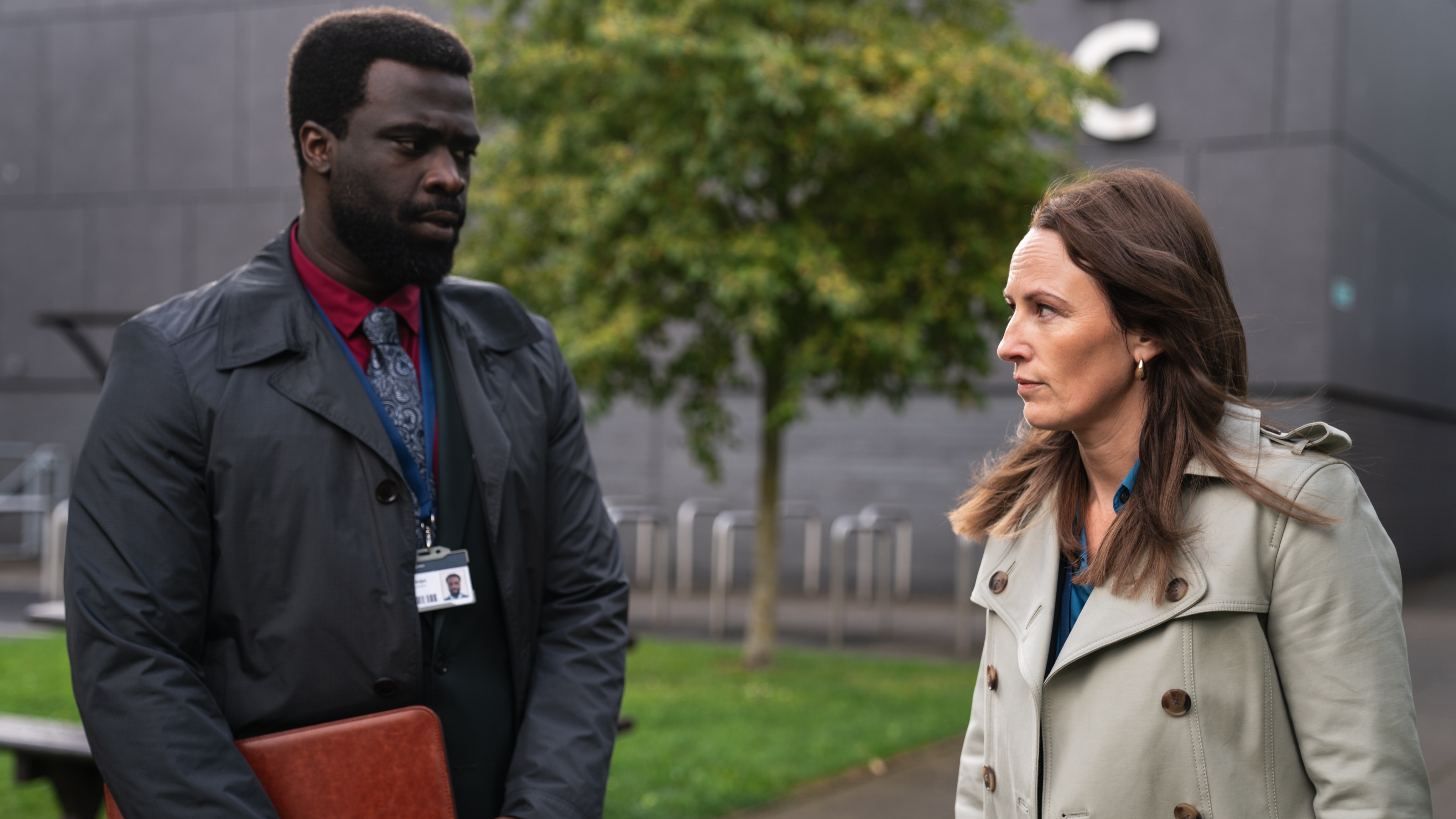 Norma and George looking stressed as they leave a meeting and stand outside an office