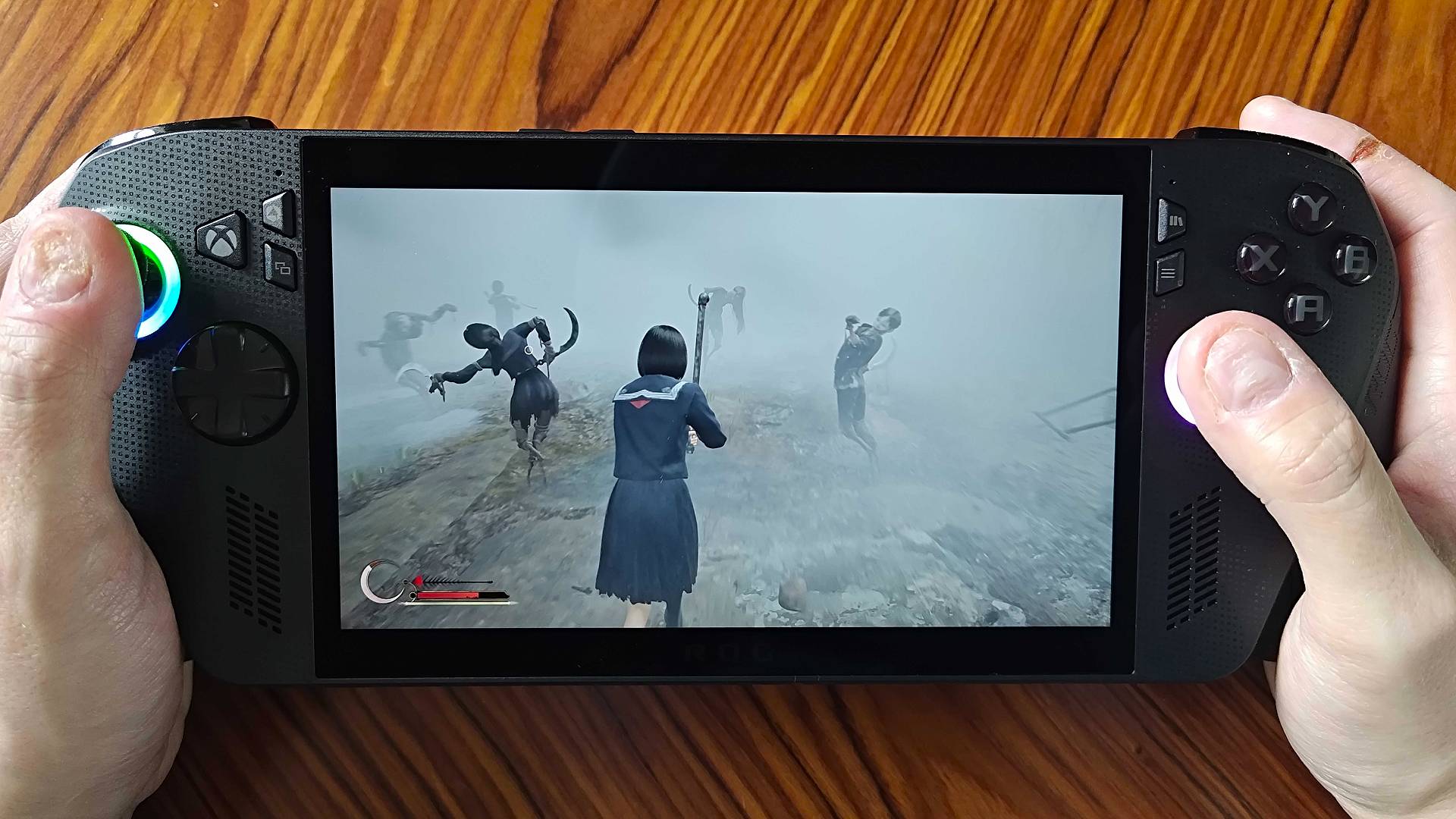 Hands holding ROG Xbox Ally X with Silent Hill F gameplay on screen.