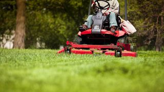 Person sitting on riding lawn mower