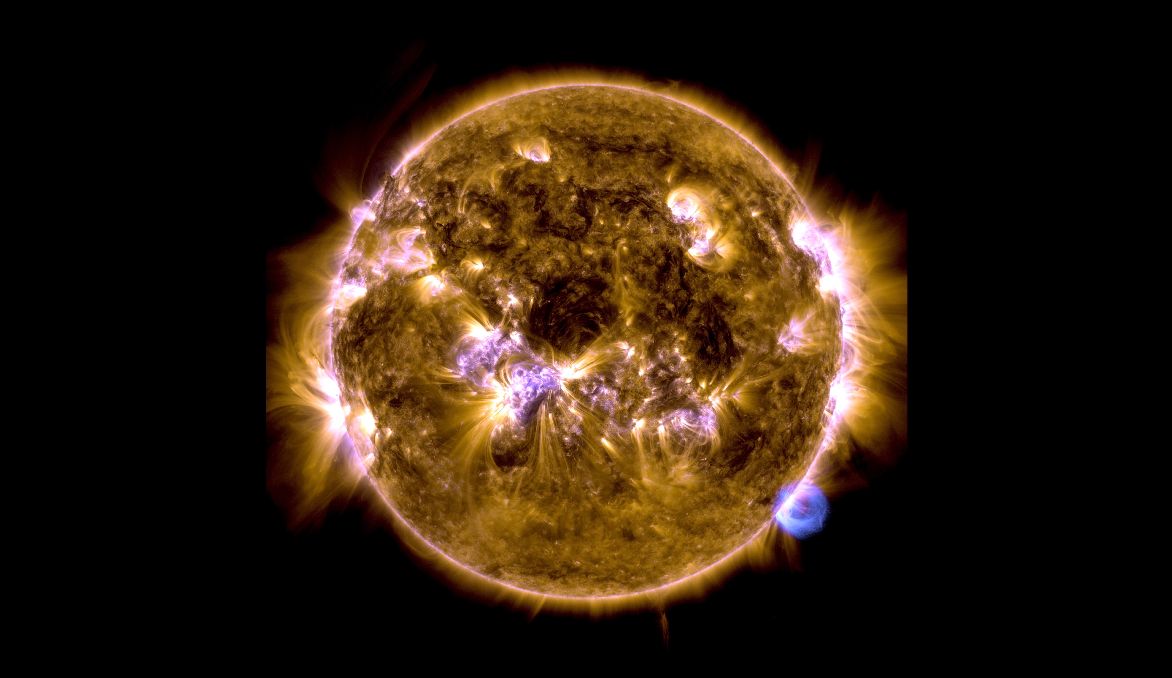 an image of the sun showing ultraviolet solar flares erupting from its surface