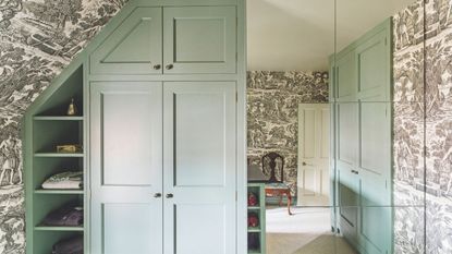 Duck egg blue closet with black and white toile du jour wallpaper and large mirror