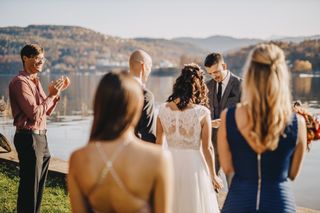 A group of wedding guests watching a bride and groom getting married