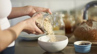 Woman pouring oats into a bowl