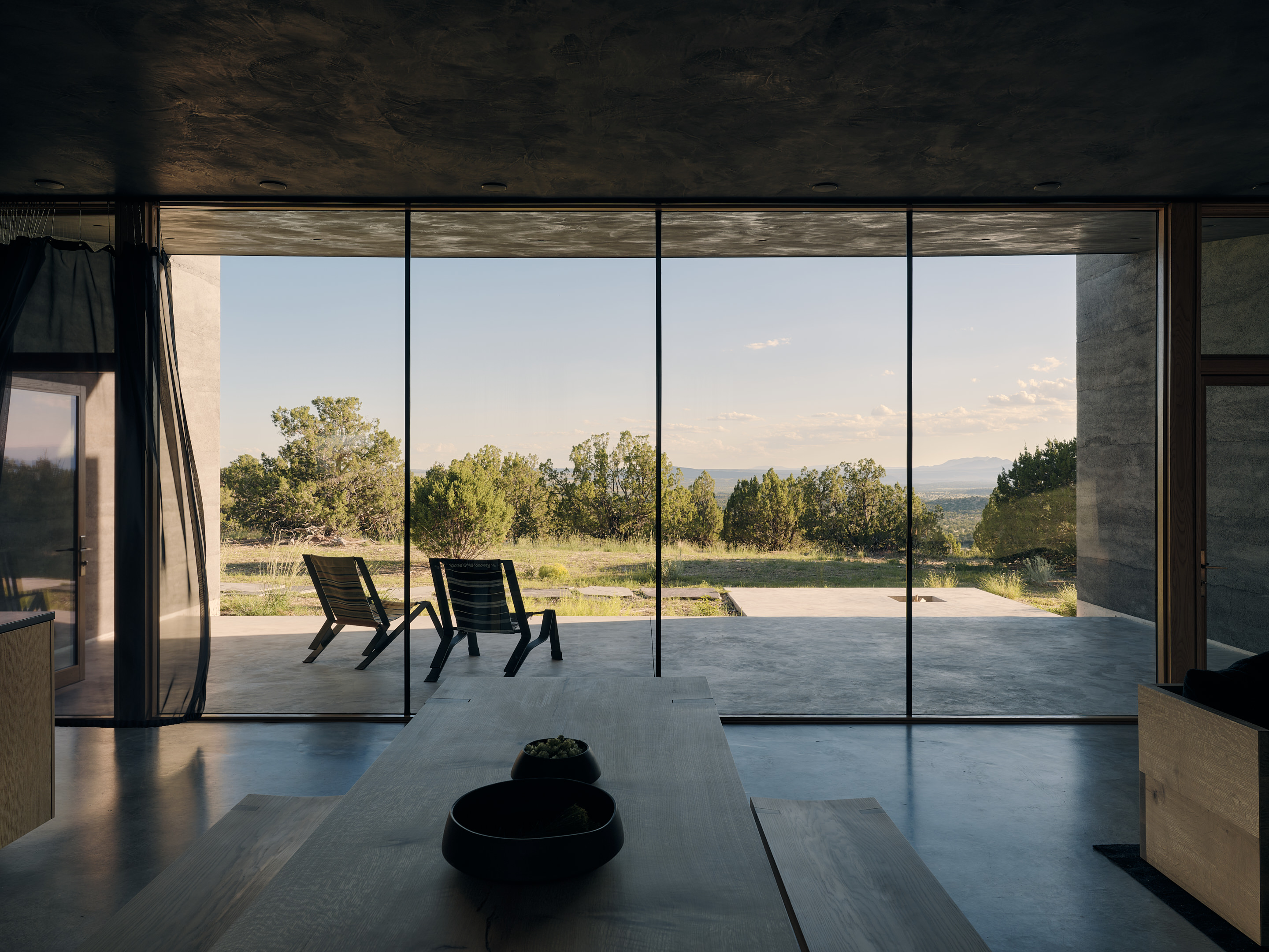 views of Sombra de Santa Fe, new mexico house, with dark, minimalist geometric volumes and clean walls and long nature views