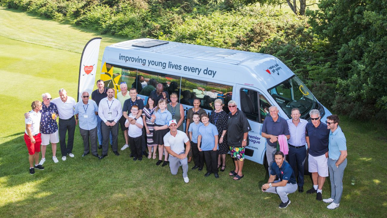 People pose for a photo by a Variety Golf van