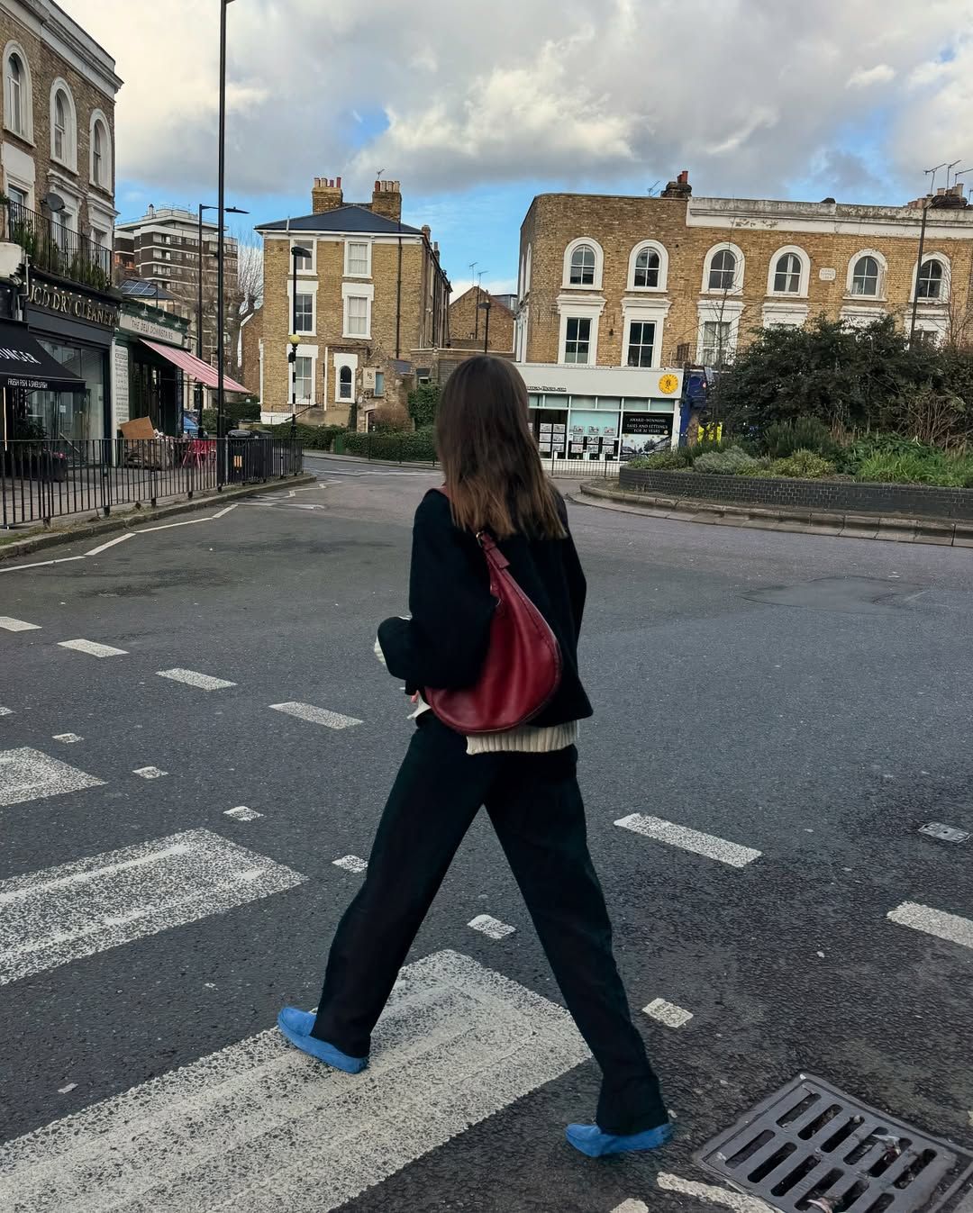 @lizzyhadfield wearing black trousers and blue shoes
