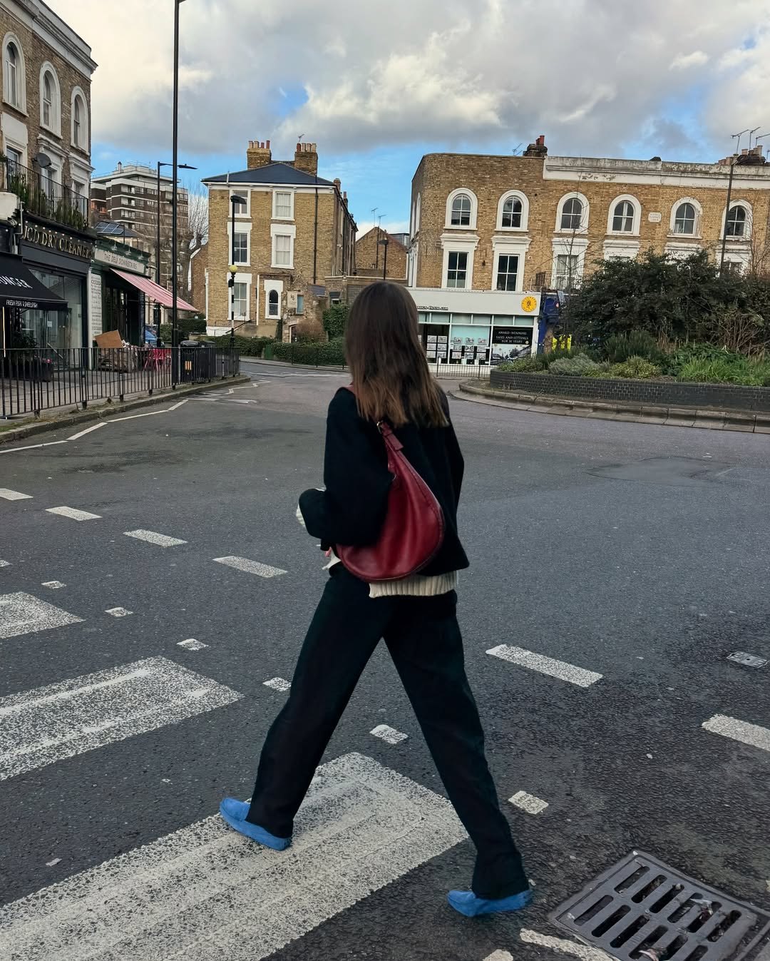 @lizzyhadfield wearing black trousers and blue shoes