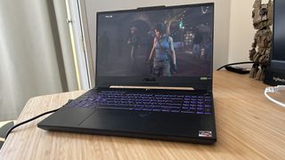 Asus TUF A15 gaming laptop open on a wooden desk and playing Shadow of the Tomb Raider