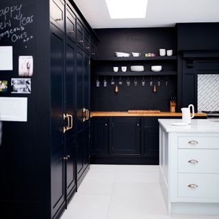 black cabinet with white cabinet and wooden countertop