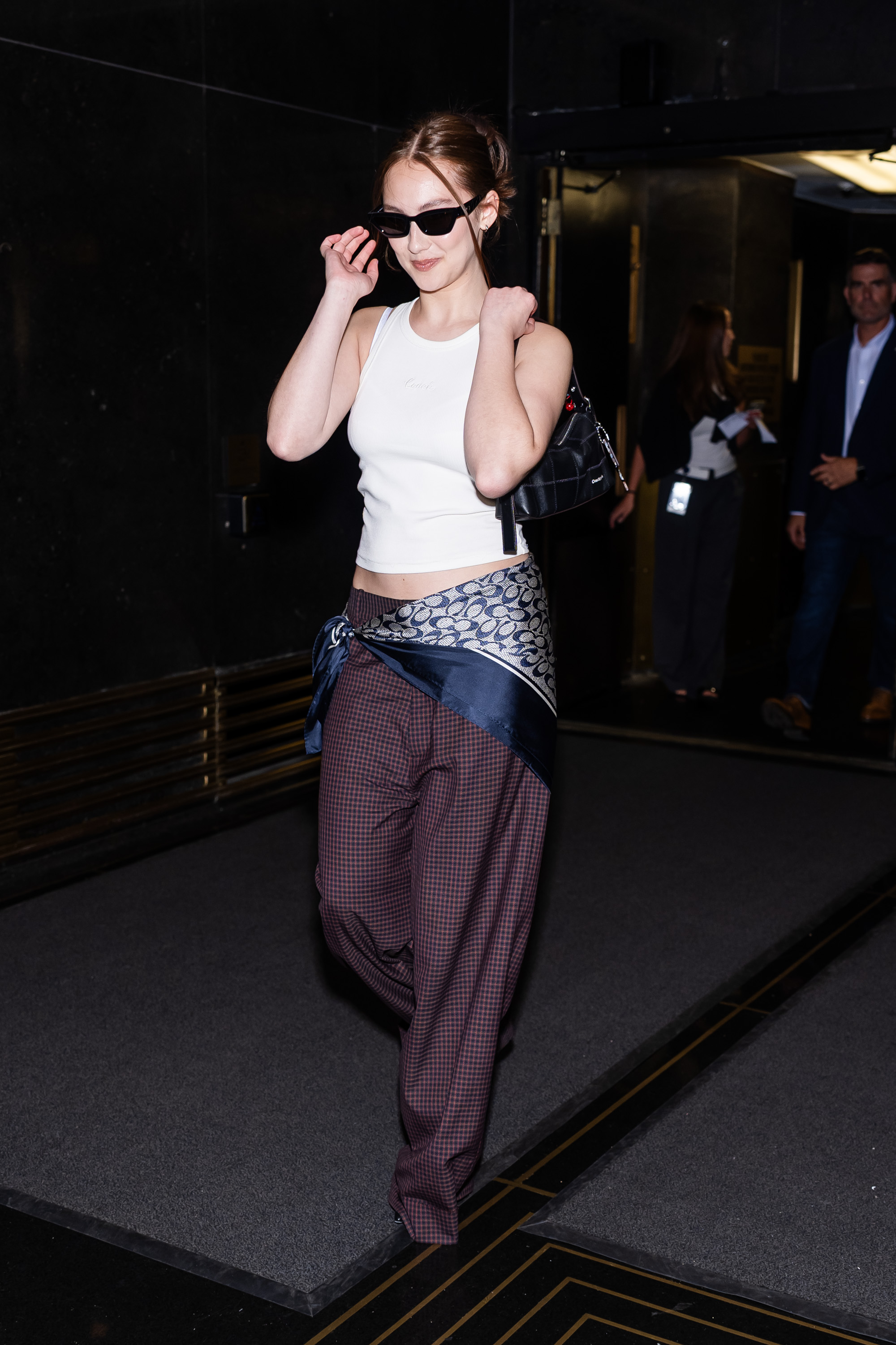 An image of a Lola Tung with a scarf belt, one of the most stylish ways to wear a scarf in 2025.