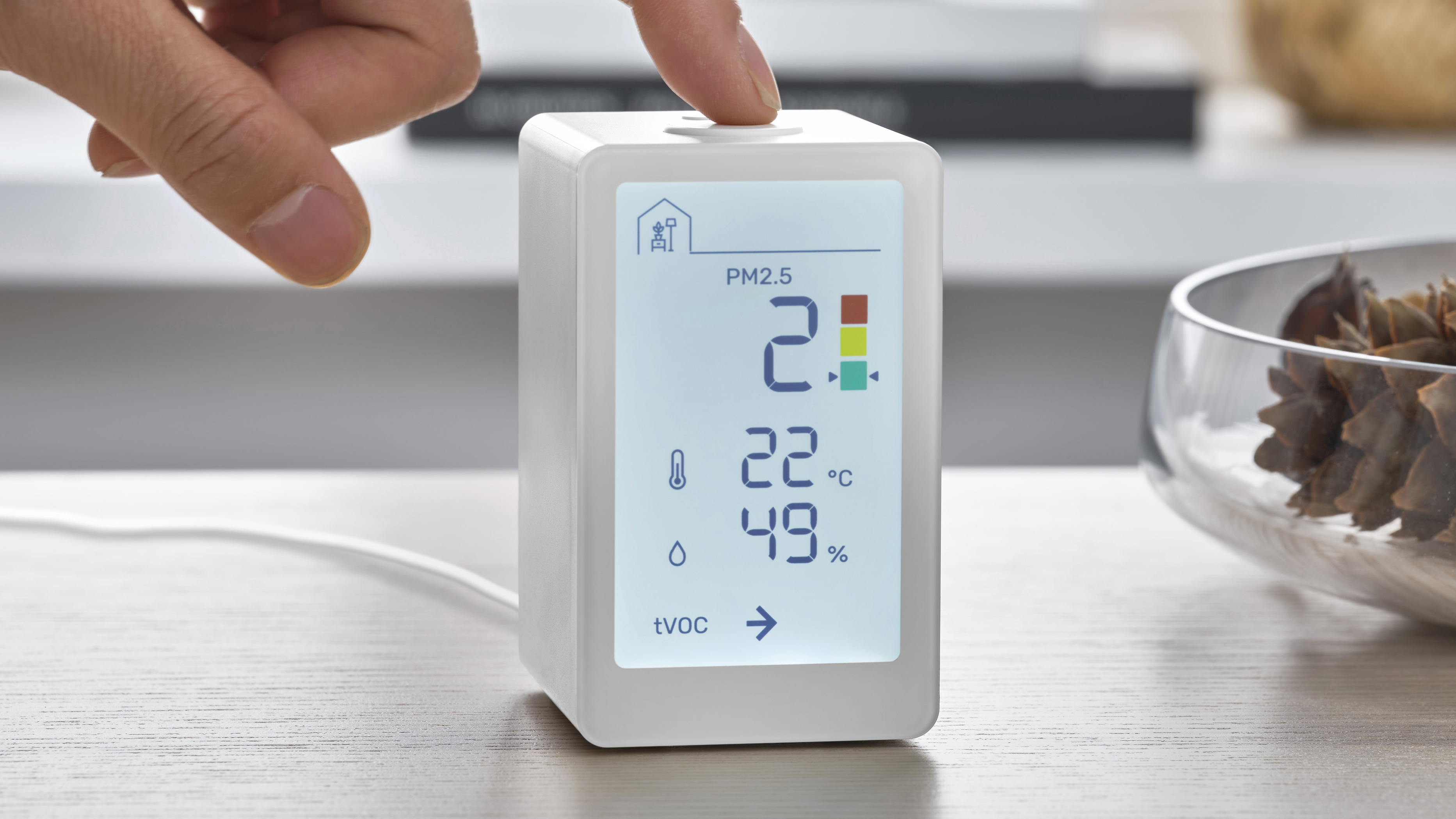 The IKEA VINDSTYRKA smart air quality monitor on a table