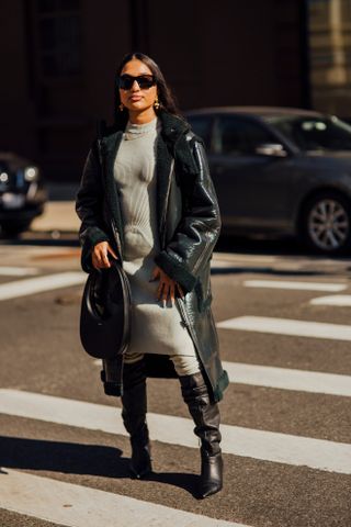 woman wearing gray dress, leather trench coat and boots