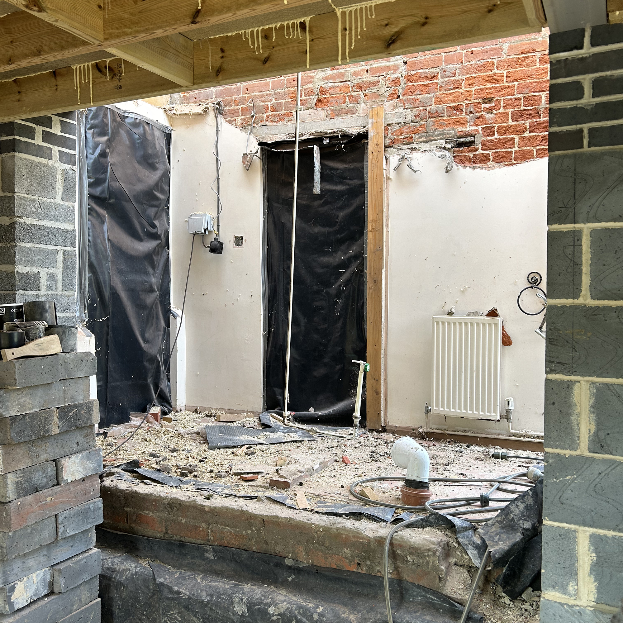 Building work of an extension, showing breeze blocks walls, and rubble left on the floor