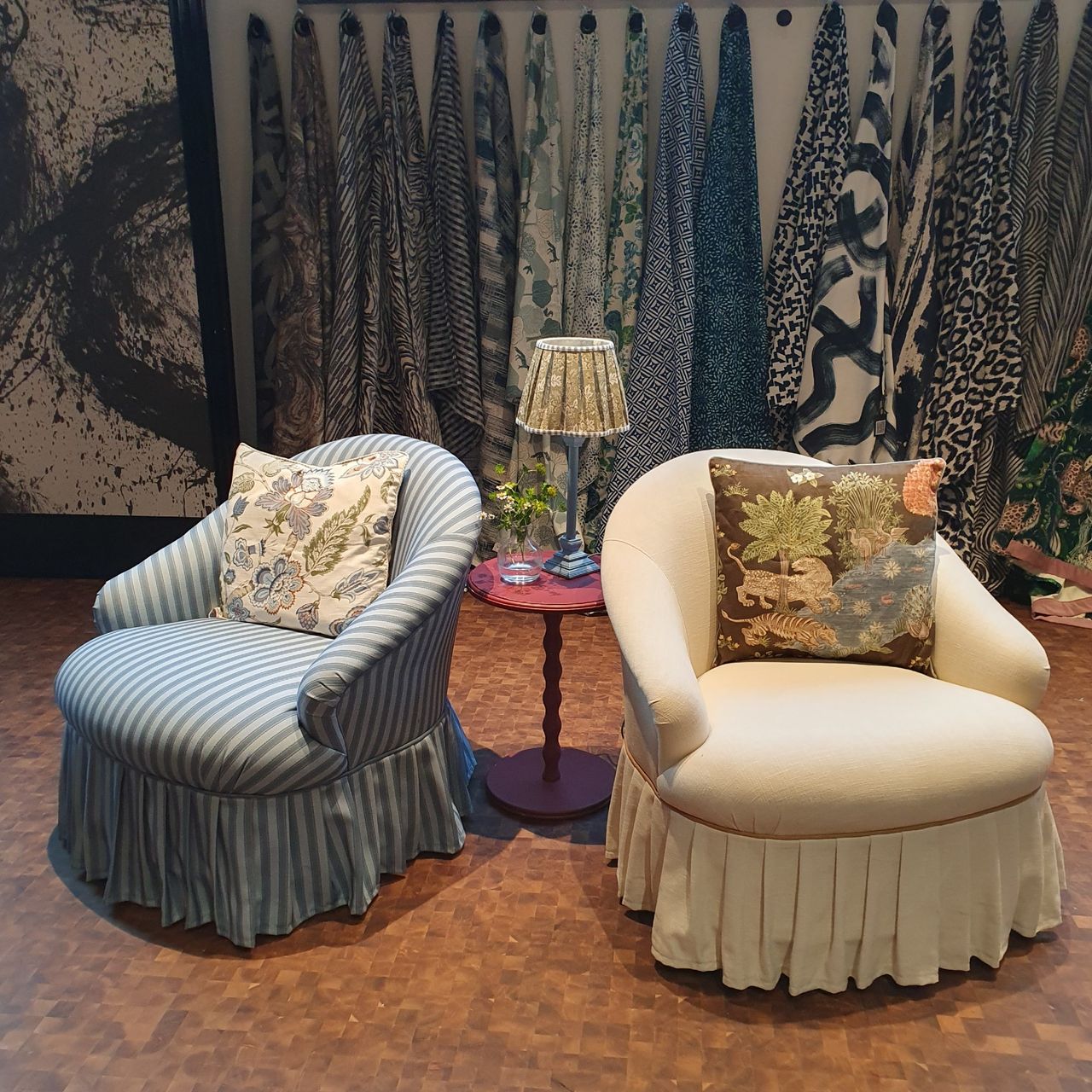 Two accent chairs with a valance and botanical-pattern cushions