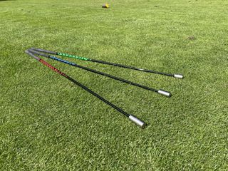 An image of the three training sticks from the SuperSpeed men's training set on grass