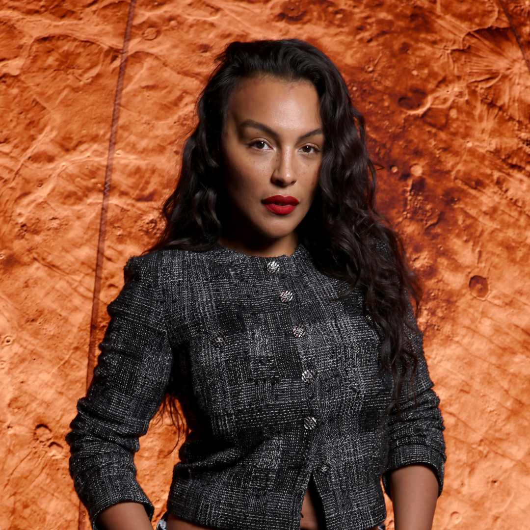 Paloma Elsesser wearing red lipstick with a wavy hairstyle.