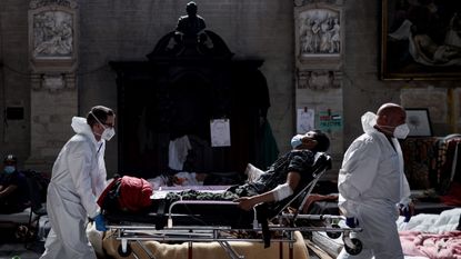 Medics evacuate a hunger striker from St John the Baptist church at the Béguinage in Brussels
