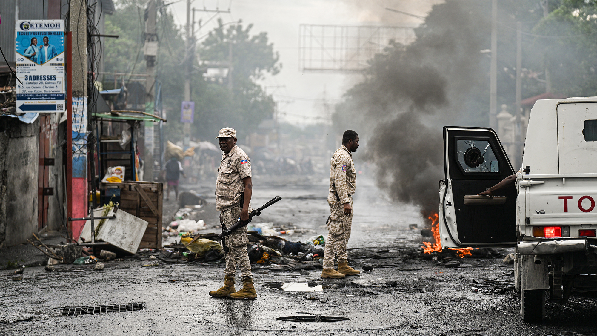 Police officers survey the damage after an anti-government protest by people displaced by gang violence, in Port-au-Prince, Haiti