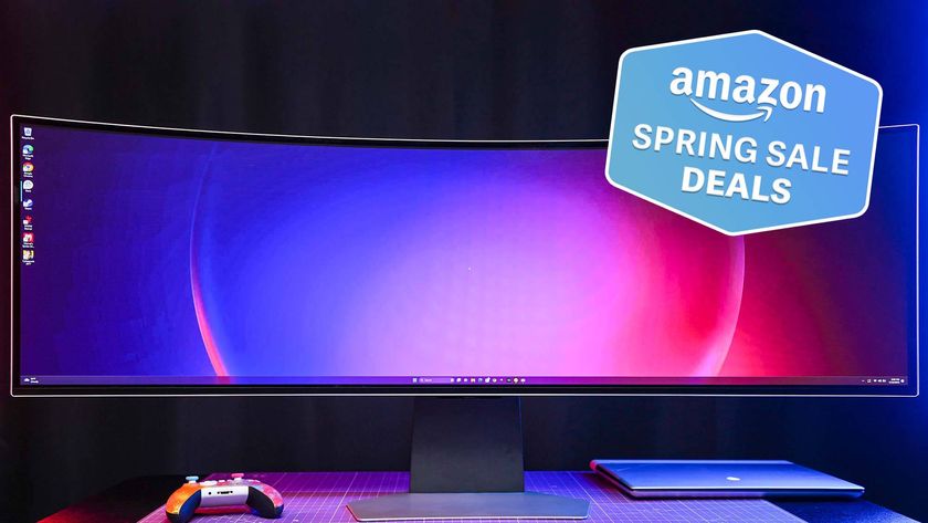 Samsung Odyssey OLED G9 on table with game controller and laptop with Tom&#039;s Guide Amazon Spring Sale Deals badge