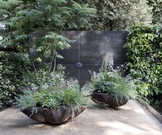 sculptured planters oversized and filled with perennial plants