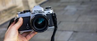 Nikon FE being held in a hand to show off the camera