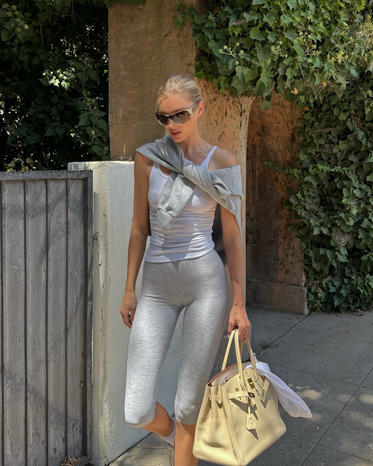 Elsa Hosk wearing a white tank top with Alo capri leggings and Sunset sneakers