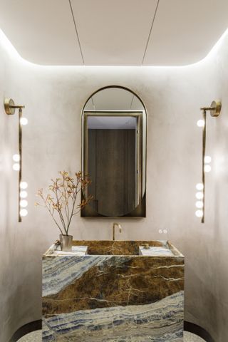a bathroom with textured walls and organic lights
