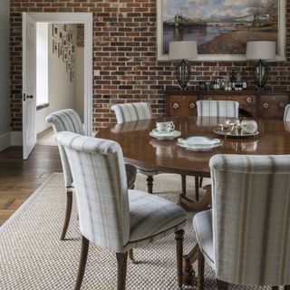 dining room with exposed brick wall and round table with chairs