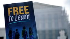 A supporter holds a 'free to learn' sign outside the U.S. Supreme Court