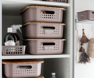 pink storage containers with bamboo lids in utility room cupboards