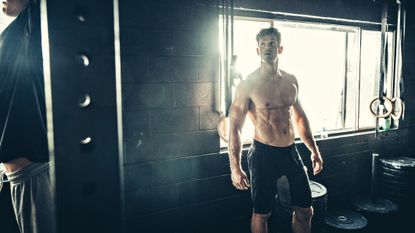 How to get a six-pack: Pictured here, a lean and muscular person standing in a CrossFit gym