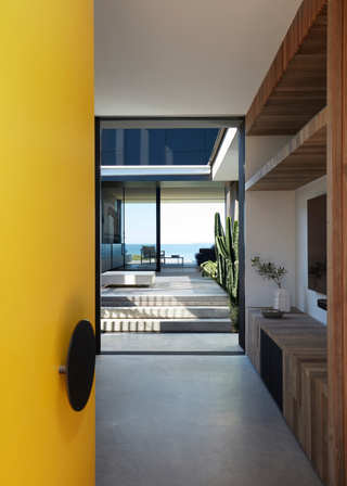 A yellow front door leading to a waterfront home