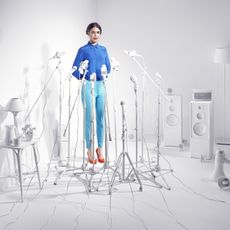 Woman standing in a room of white microphones.