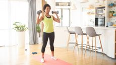 Woman exercising with dumbbells at home