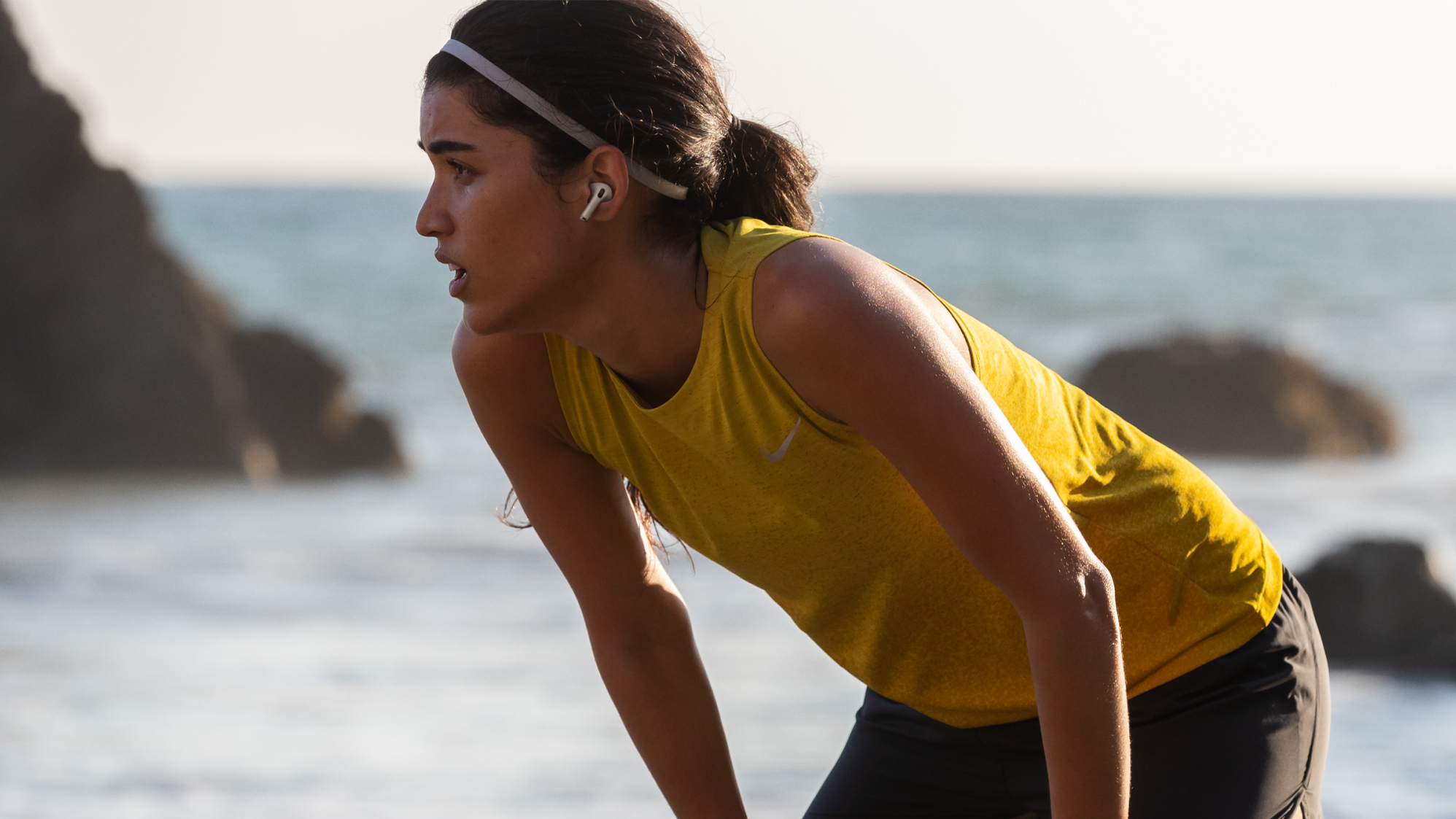 a runner wearing the airpods pro at the beach