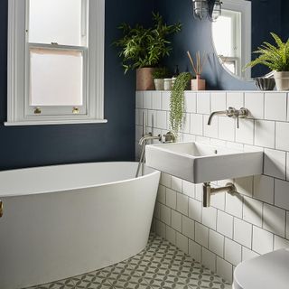 Bathroom with oval bathtub and dark blue painted walls
