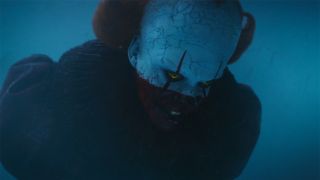 Pennywise face half covered in blood looking down in IT: Welcome To Derry