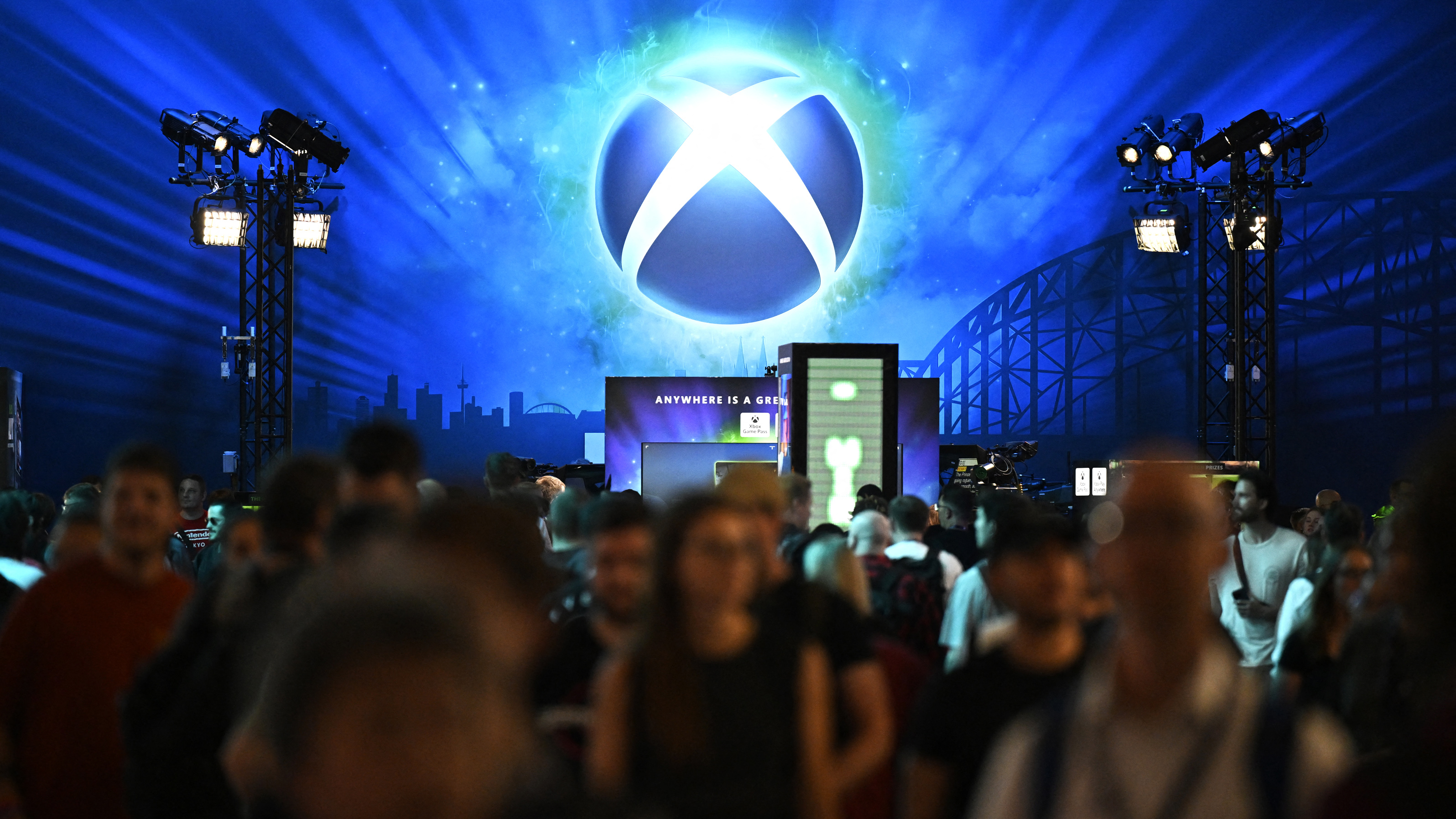 Visitors walk in front of the Xbox booth during the Gamescom video games trade fair at the Trade Fair Center in Cologne, western Germany, on the first day of the fair on August 20, 2025. The 2025 edition of the vast Gamescom trade fair in Cologne, Germany, had its opening night on August 19, 2025 and will be running from August 20 to 24, 2025. (Photo by Ina FASSBENDER / AFP) (Photo by INA FASSBENDER/AFP via Getty Images)
