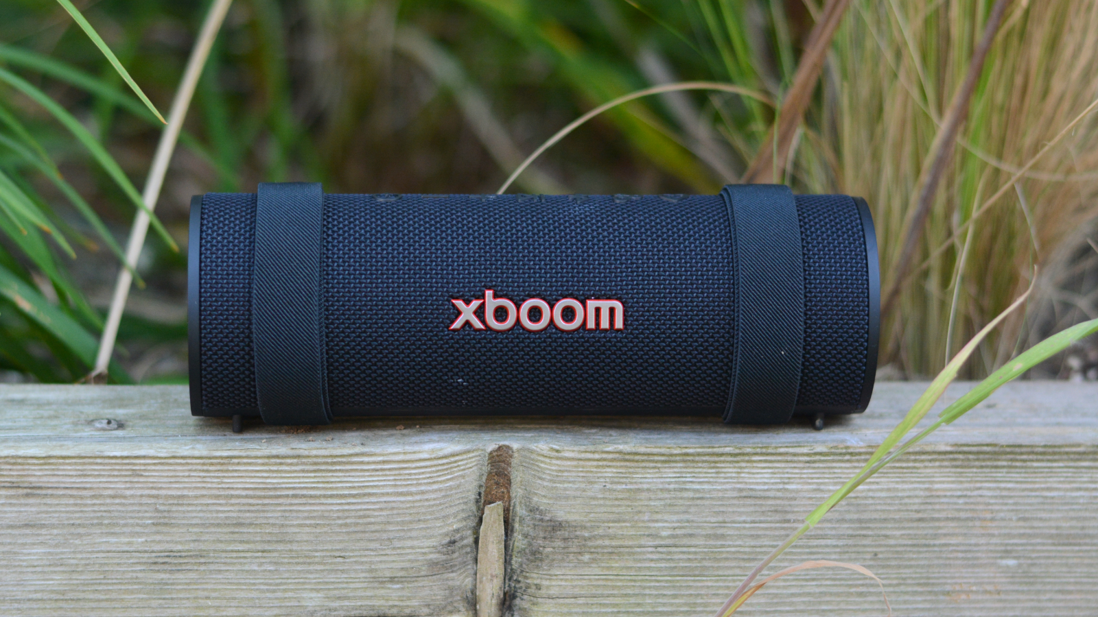LG xboom Grab Bluetooth speaker in an outdoor setting