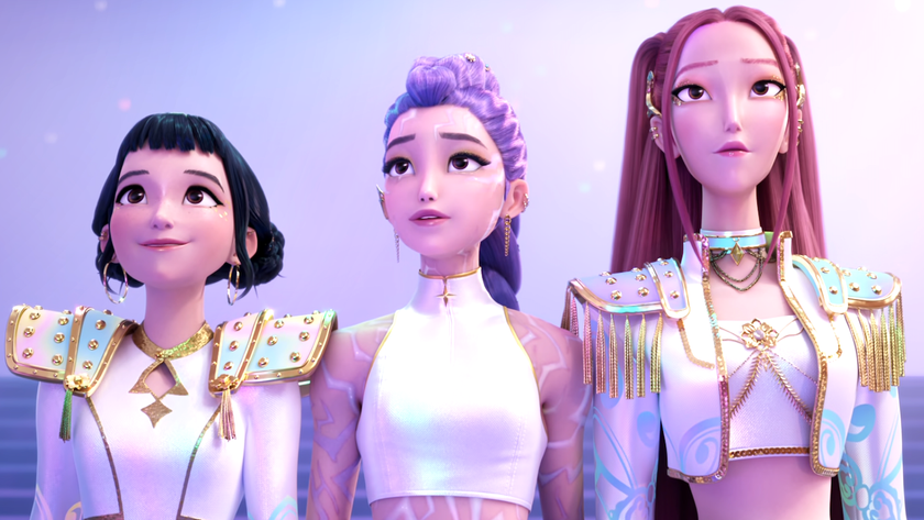 Zoey, Mira and Rumi looking at a crowd proudly while in matching white and gold costumes near the. end of KPop Demon Hunters 