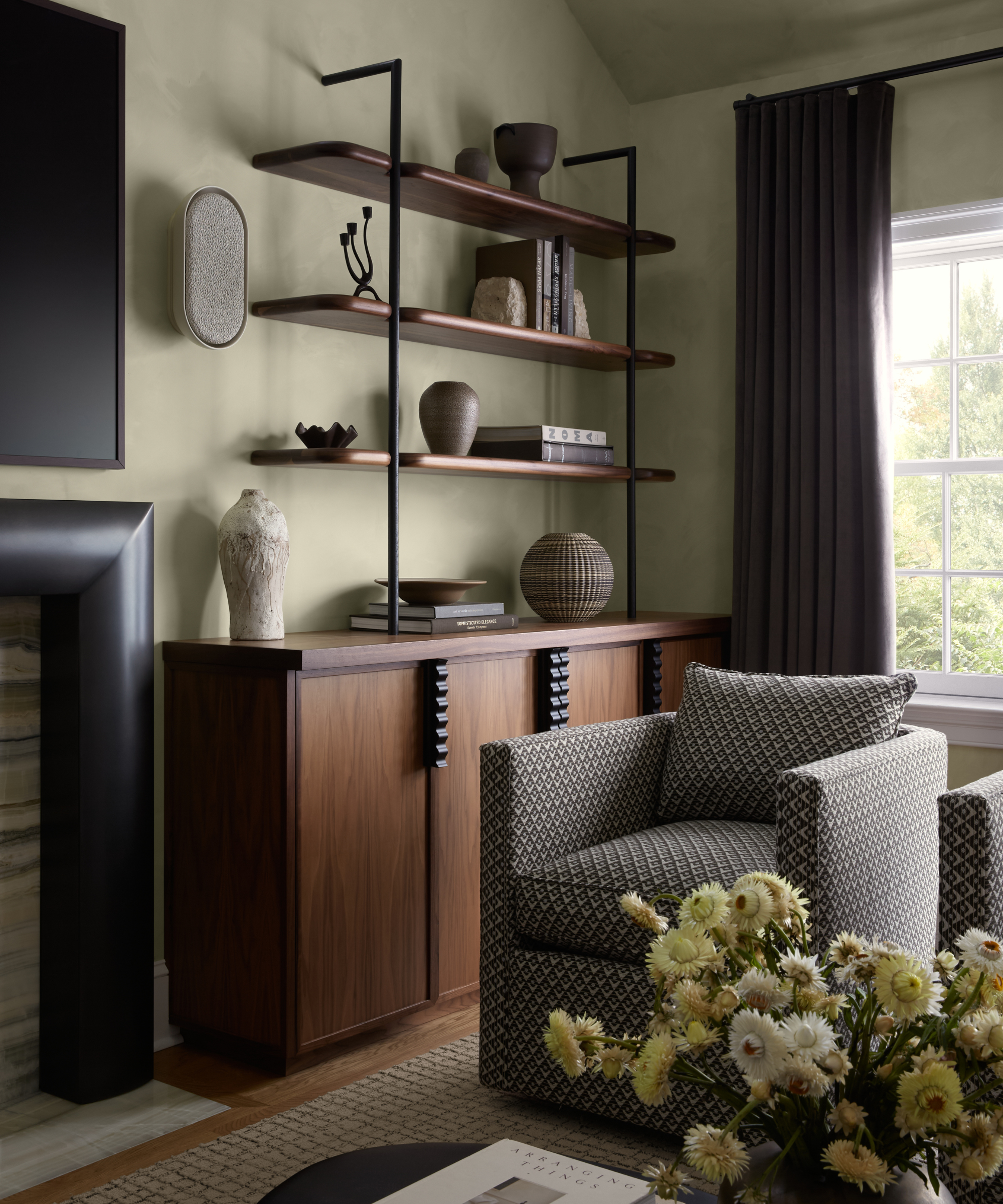 a living room with a large open shelving unit with decorative objects and books on each shelf