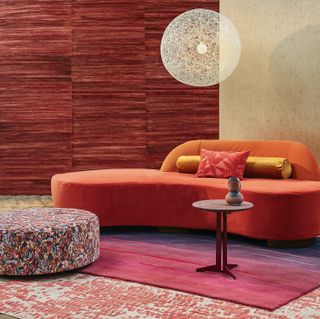 red curved sofa and red rug in a living room