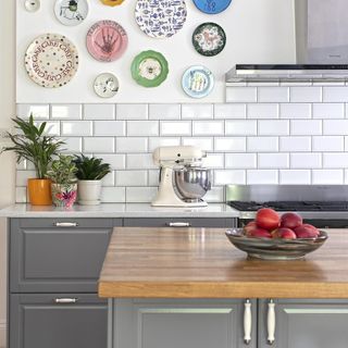 kitchen room with white tiled wall and plant in pots