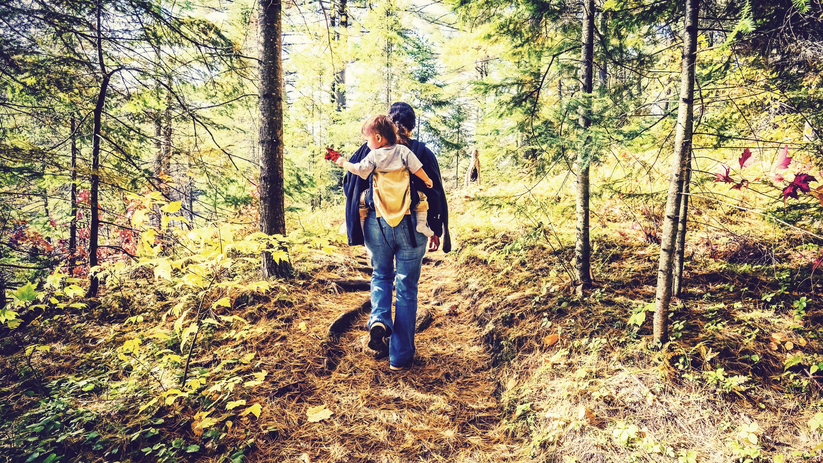 a woman walking with her baby in a sling