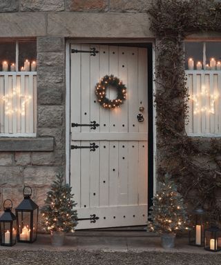 Front door and windows decorated with outdoor and indoor christmas lights
