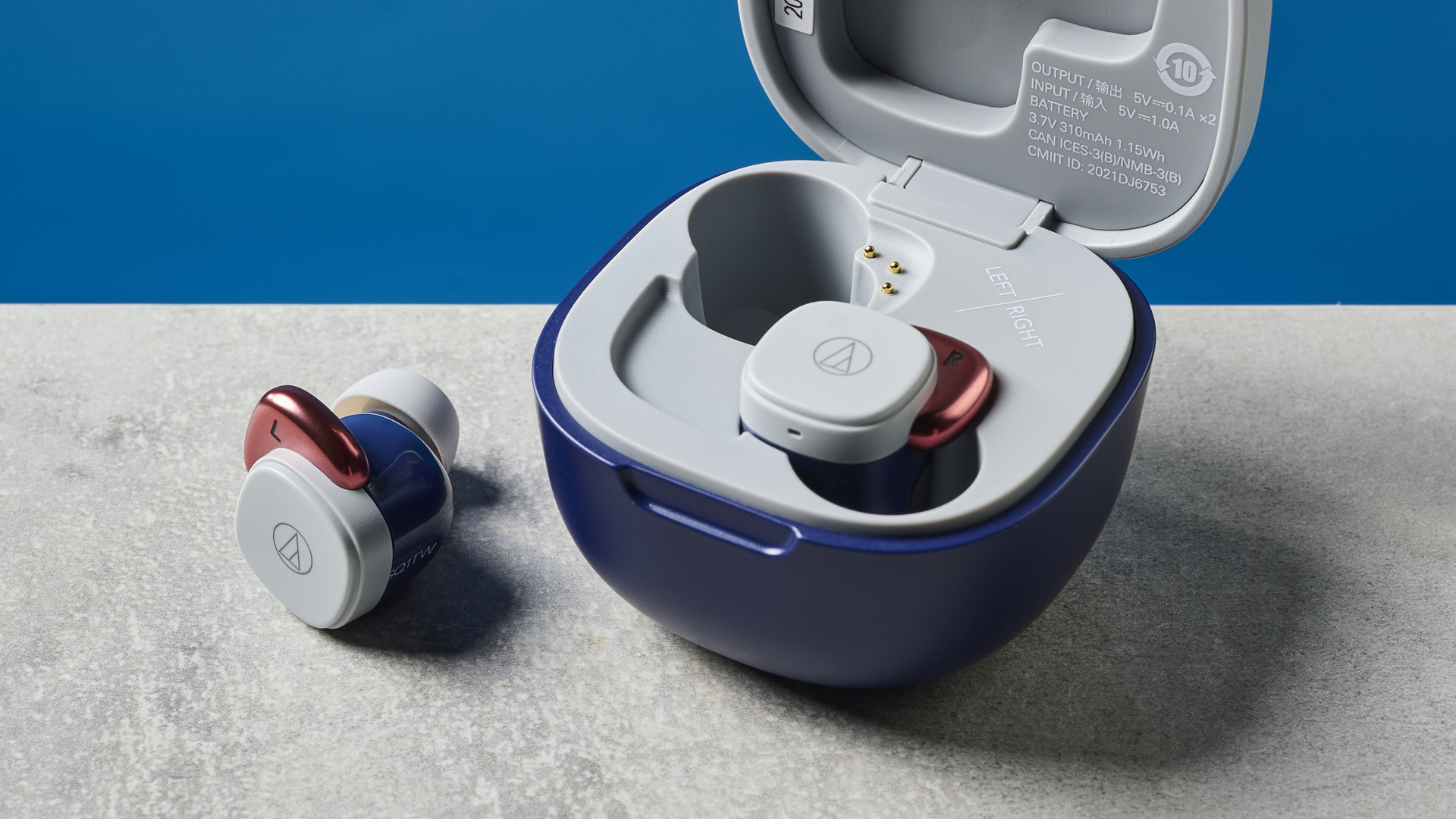 A pair of Audio-Technica ATH-SQ1TW wireless earbuds, one sitting in the case and one outside