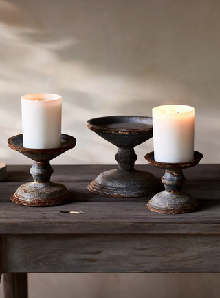 three antique-style pillar candle holders of different heights